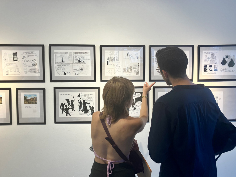 Exhibition visitors in front of works from the graphic novel series “Gestern haben wir viel getanzt” (“Yesterday we danced a lot”) by illustrator Nathalie Frank, Berlin 2023.
